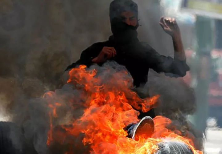 Palestinos bloquean una calle con neumático. Foto: EFE 