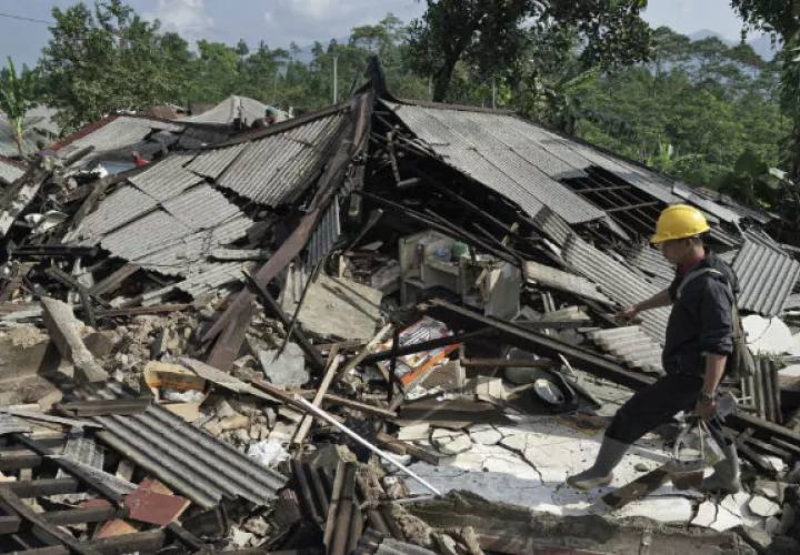 Un socorrista camina sobre los escombros de las casas. Foto: AP 