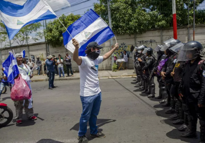 Manifestantes son bloqueados por agentes antidisturbios durante una marcha. FOTO/EFE
