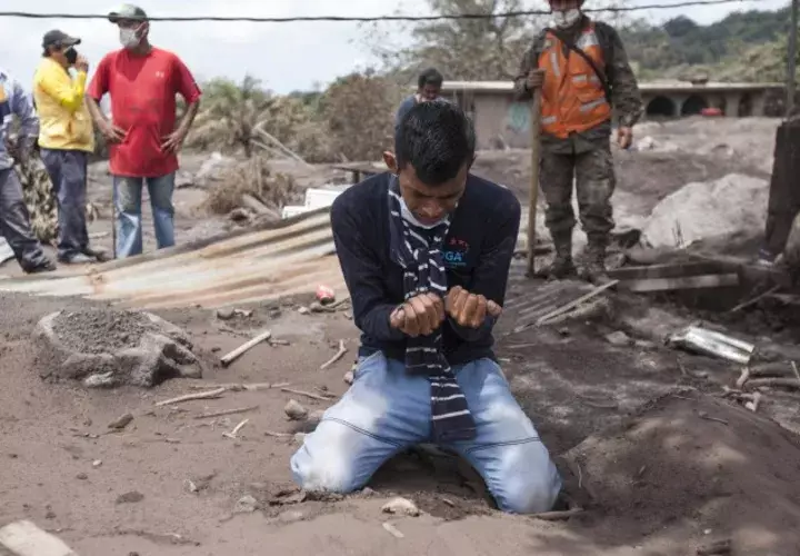 Bryan Rivera llora en medio del lugar que era su casa y donde perdió a sus familiares debido a la erupción del volcán. AP