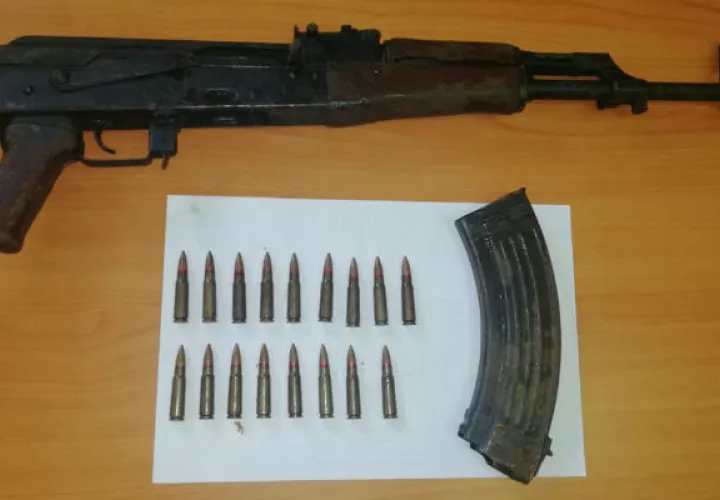 El arma encontrada, junto a varias municiones. 