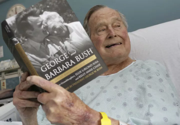 George H.W. Bush, disfruta del libro que cuenta su historia con la difunta Bárbara Bush. FOTO/AP