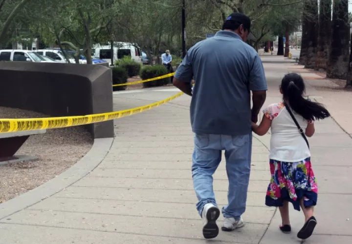 Un hombre camina junto a su hija tras salir de una cita del ICE. EFE