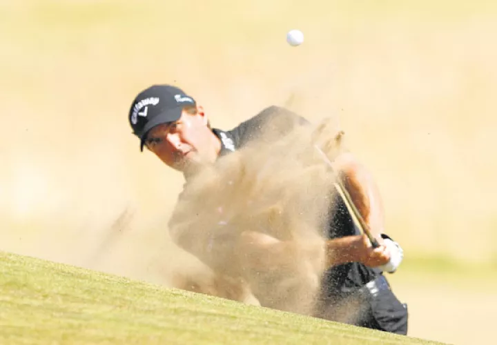 El estadounidense Kevin Kisner  mientras escapa del bunker del hoyo 17 de  Carnoustie. /Foto AP