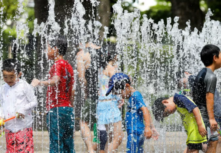 Varios niños juegan en los chorros de agua de una fuente en un parque cerca de Nerima. Foto: EFE 