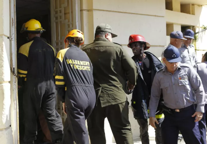 Bomberos y policías ingresan al Instituto Nacional de Oncología y Radiobiología. FOTO/EFE