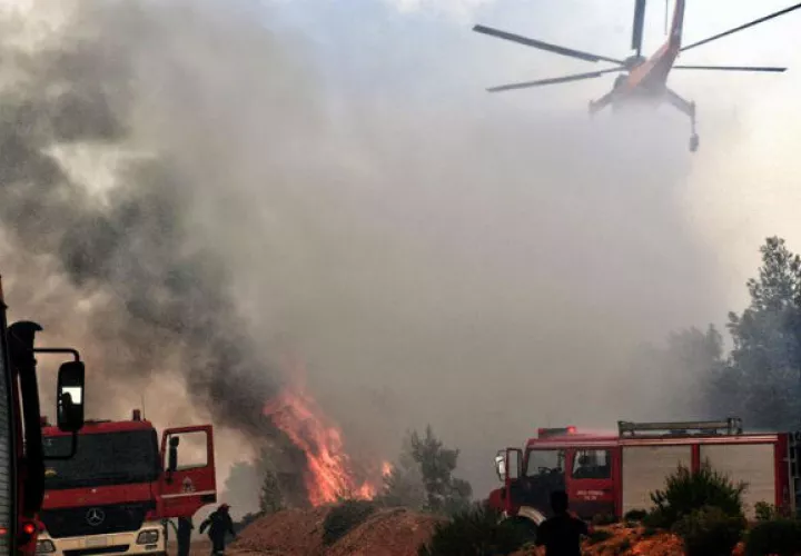 Un helicóptero intenta extinguir un fuego en Verori. Foto: EFE 