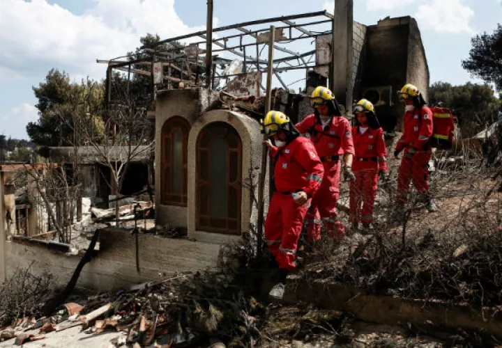 Miembros de la Cruz Roja buscan desaparecidos. Foto: EFE 