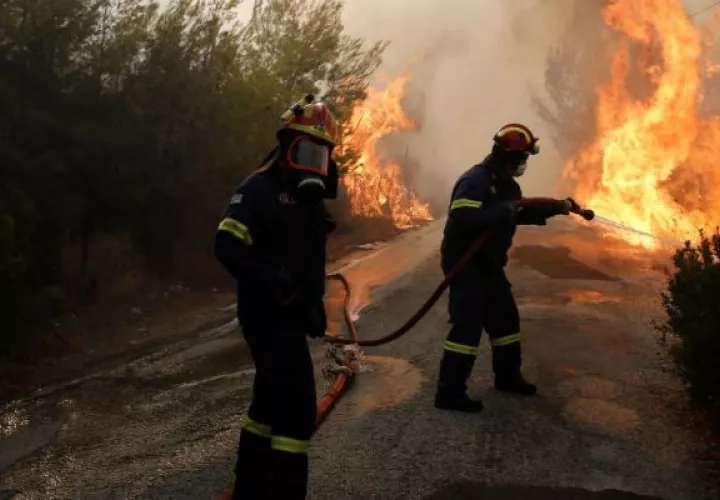 Bomberos tratan de extinguir un incendio en Penteli. Foto: EFE 