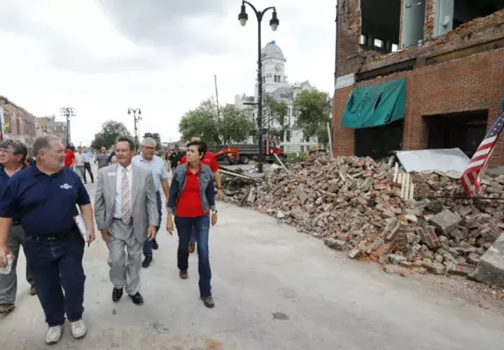 El gobernador de Iowa, Kim Reynols (de gris), inspecciona los daños. 