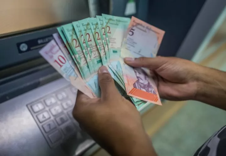 Una persona cuenta dinero del nuevo cono monetario retirado de un cajero. /Foto EFE