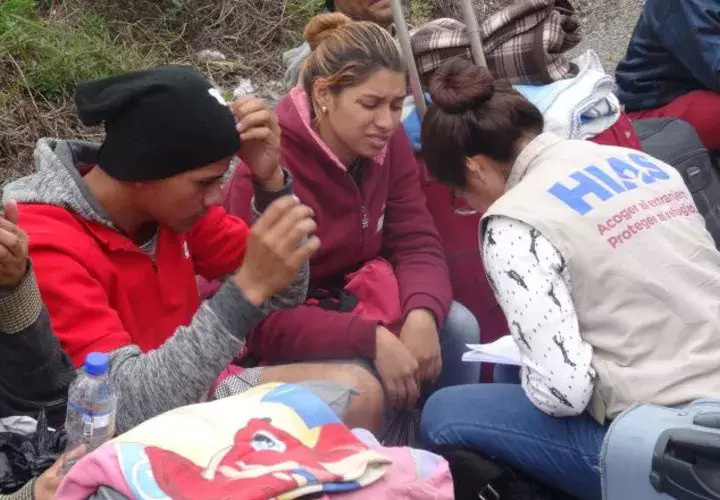 Inmigrantes venezolanos hablan con personal de una organización de ayuda al refugiado en Tulcán (Ecuador). EFE