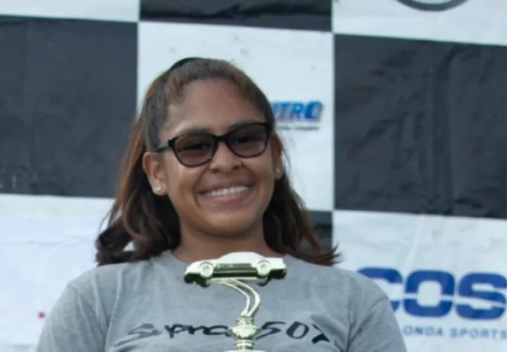 La piloto posa sonriente con su trofeo.