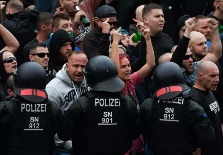 Manifestantes de derecha hacen gestos hacia la policía antidisturbios. Foto: EFE.