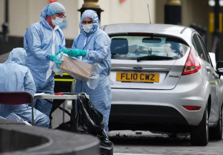 Oficiales forenses examinan el coche que chocó contra las barreras del Parlamento británico. Foto: EFE