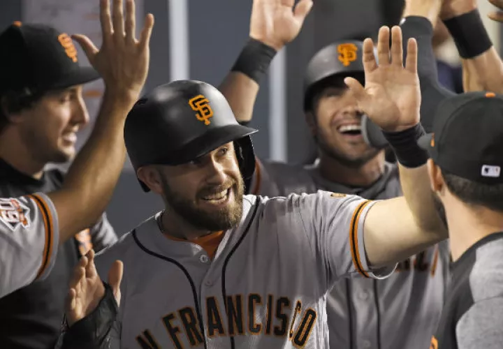 Evan Longoria de San Francisco es felicitado por sus compañeros. Foto:AP