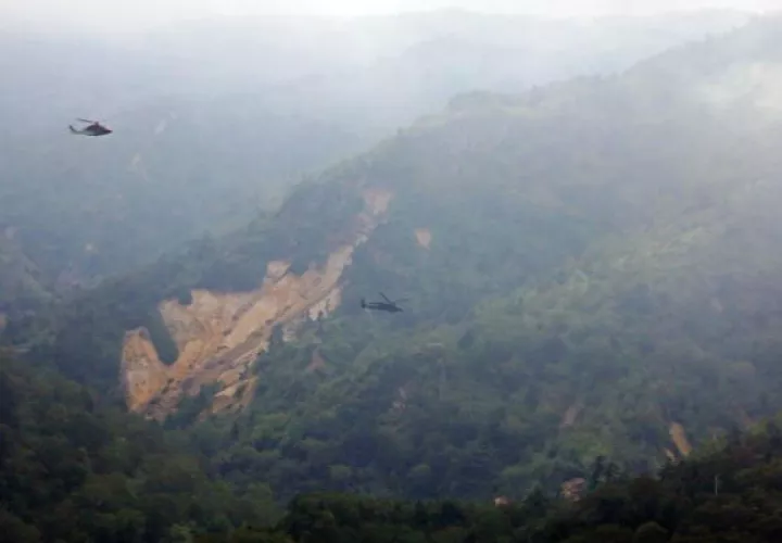Un helicóptero de las operaciones de rescate sobrevuela la zona donde un helicóptero se estrelló. Foto: EFE  