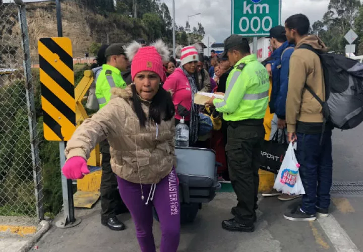 Policías ecuatorianos controlan una fila de emigrantes venezolanos en Rumichaca. Foto: EFE. 
