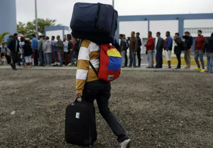 Venezolano camina hacia Perú con su equipaje. 