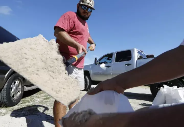 Un grupo de personas protegen sus casas ante la llegada del huracán Florence. AP