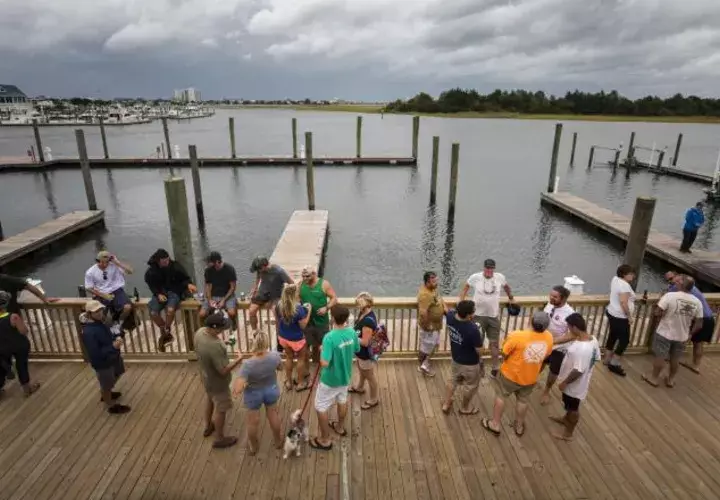 Un grupo de personas se reúne afuera del restaurante Dockside en lo que han denominado como "fiesta de huracán". EFE