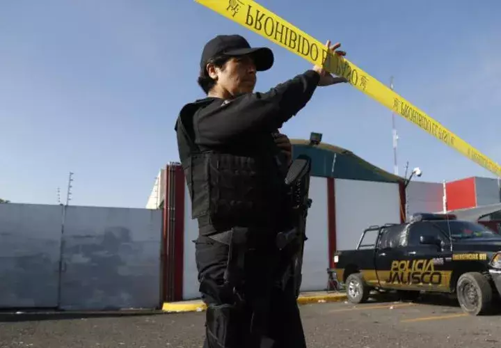 Un policía presta guardia en las inmediaciones del Instituto Jalisciense de Ciencias Forenses. EFE