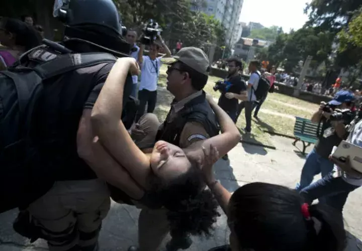 Una estudiante se deja llevar por atención médica después de desmayarse frente al Museo Nacional. Foto: AP