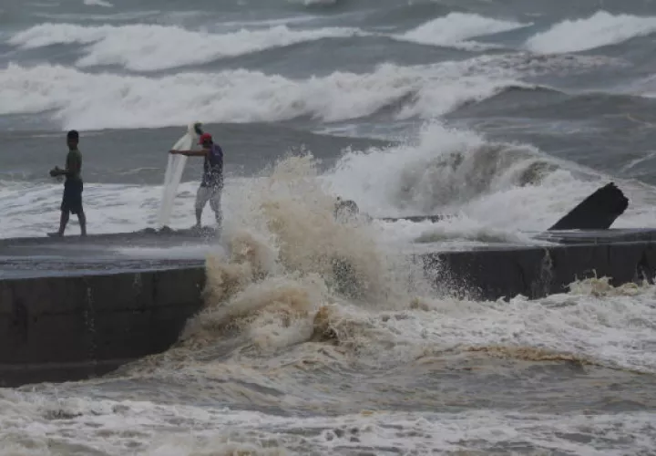 Hombres pescan en la orilla ante el peligro de las olas por llegada del tifón Mangkhut. Foto: EFE
