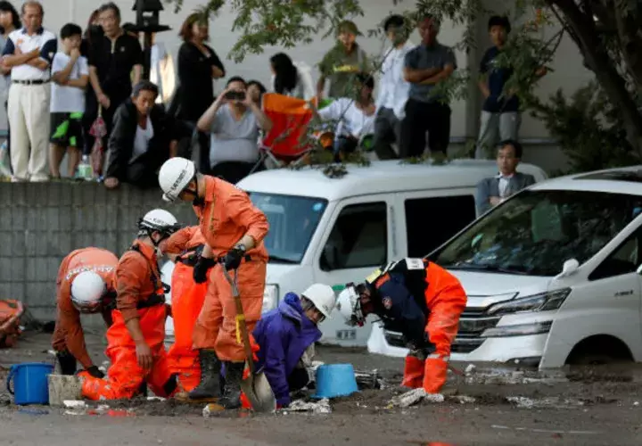 Una trabajadora de HTB (2-d) es rescatada por los servicios de emergencias tras verse atrapada en el lodo por el terremoto en Japón. EFE