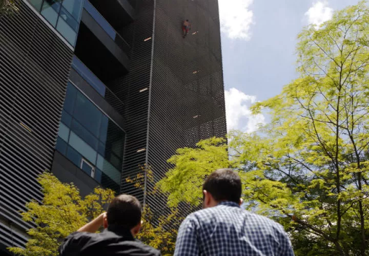 El escalador ruso Pavel Gogulan (i), conocido internacionalmente como el "Spiderman ruso", escala, si ningún tipo de protección, un edificio en Medellín. FOTO/EFE
