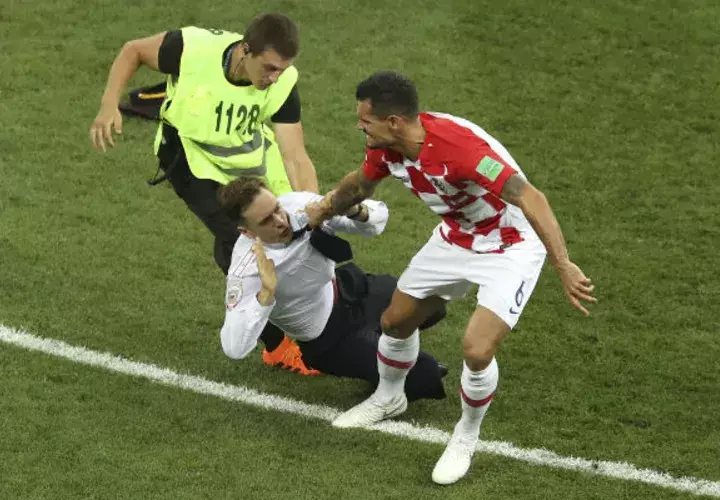 Pyotr Verzilov (cent.) en la final del mundial de Rusia es atrapado por un seguridad. Foto:AP 