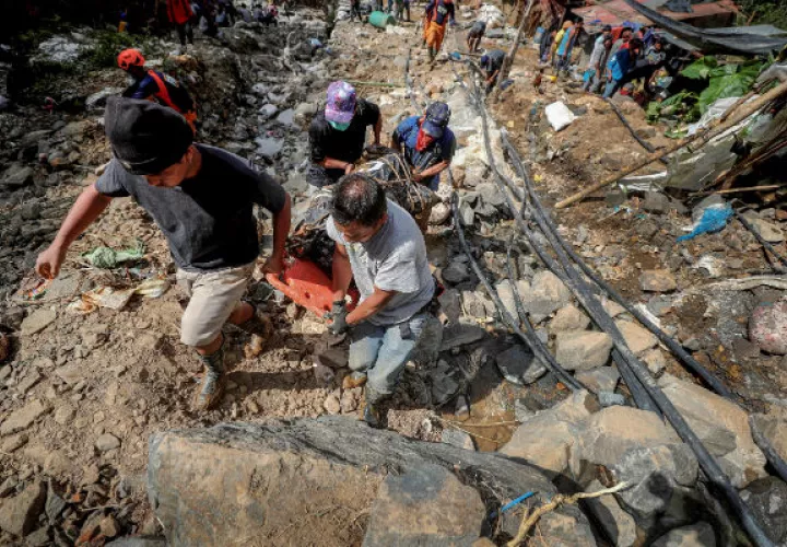 Filipinos cargan con el cuerpo de una víctima de un deslizamiento de tierra causado por el tifón Mangkhut en Filipinas. EFE