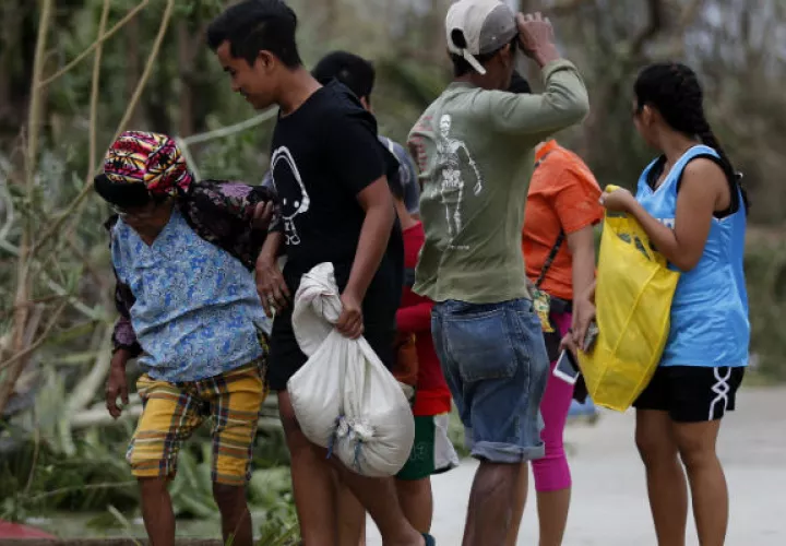 Los aldeanos filipinos caminan en la ciudad de Baggao, provincia de Cagayan, Filipinas, azotada por el tifón Mangkhut. FOTO/AP