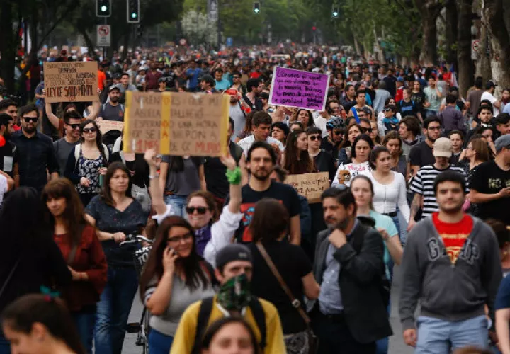  Encapuchados montan barricadas frente a la policía tras manifestarse en el centro de Santiago. Foto: EFE.