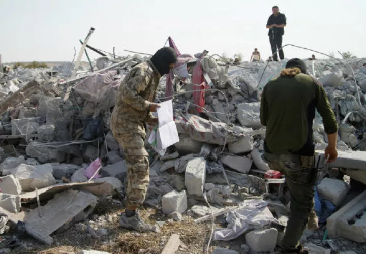 Personas sobre el edificio destruido en Barisha, Siria, donde murió el líder del Estado Islámico. Foto: EFE.