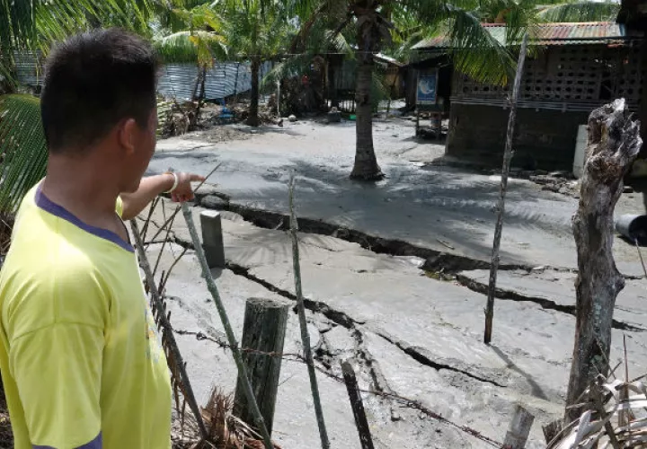 Pobladores observan una grieta en la calle tras el sismo en Digos, Filipinas. Foto: EFE. 