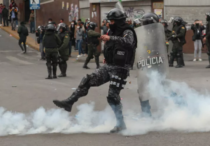 Un simpatizante el expresidente Evo Morales devuelve una lagrimógena a los antimotines. Foto: AP