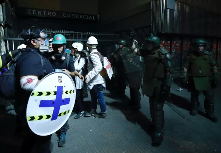 Carabineros dispersan aun grupo de médicos que atienden a los heridos durante las protestas. FOTO/AP