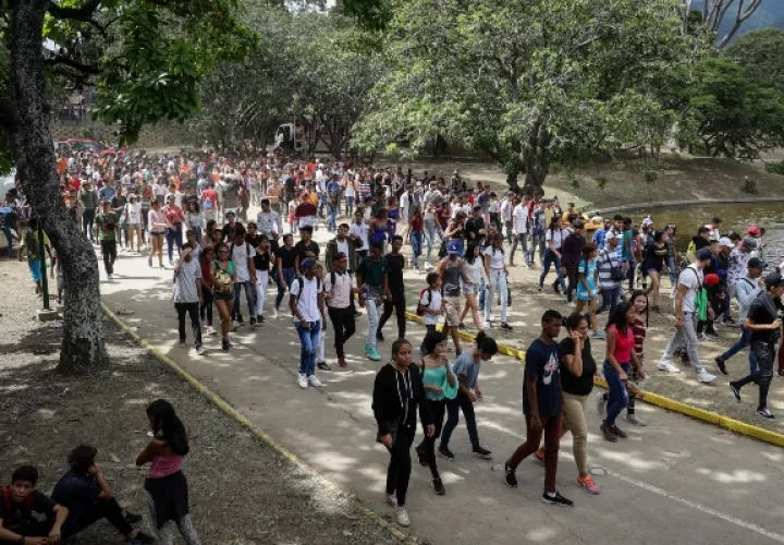 Personas cruzan una laguna tras salir de un concierto en las instalaciones del Parque Generalisimo Francisco de Miranda este sábado en Caracas. FOTO/EFE
