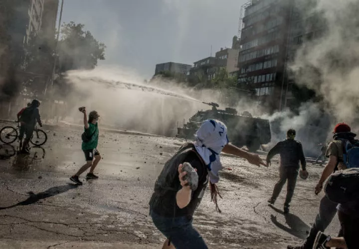 La clase media chilena lucha con precios altos y sueldos bajos. Un reciente choque con la Policía en Santiago. Foto/ Tomas Munita para The New York Times.