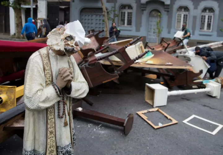 Manifestantes retiran objetos de la Parroquia de La Asunción, en la céntrica Plaza Italia, en Santiago (Chile). Foto: EFE.
