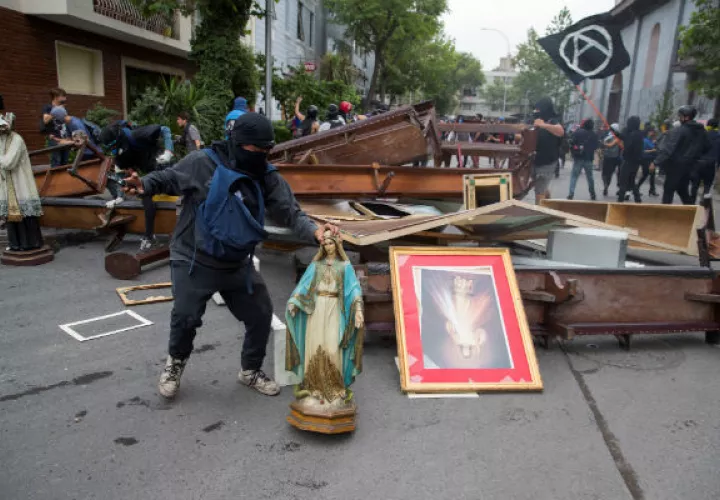 Manifestantes retiran objetos de la Parroquia de La Asunción, en la céntrica Plaza Italia, en Santiago (Chile). Foto: EFE.
