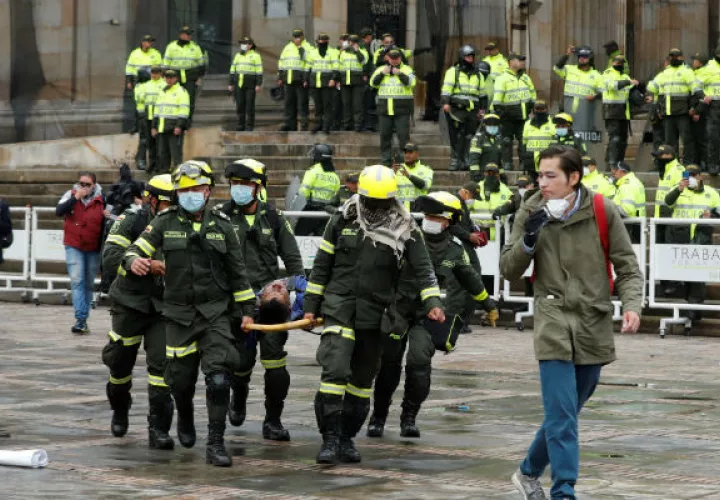 Equipos de emergencia atienden a un herido durante el cacerolazo en la Plaza Bolívar de Bogotá. Foto: EFE.
