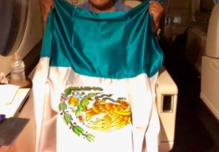 El expresidente de Bolivia Evo Morales posa con una bandera mexicana, durante su viaje en un avión de la Fuerza Aérea Mexicana.