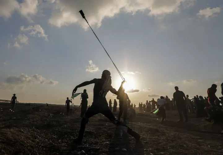 Un  israelí observa su vehículo impactado por misiles tirados desde la Franja de Gaza. Foto: AP. 