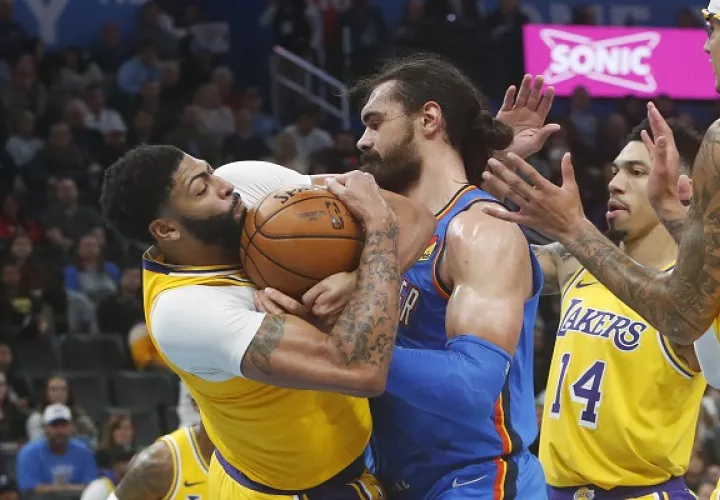 Anthony Davis (izq.) de los Lakers lucha por el balón contra Steven Adams de los Thunder. Foto:AP 