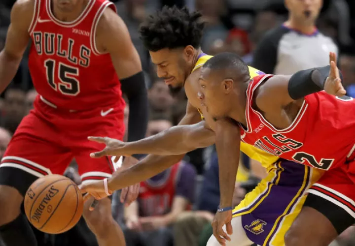Quinn Cook, de los Lakers, disputa el balón con Kris Dunn. Foto AP