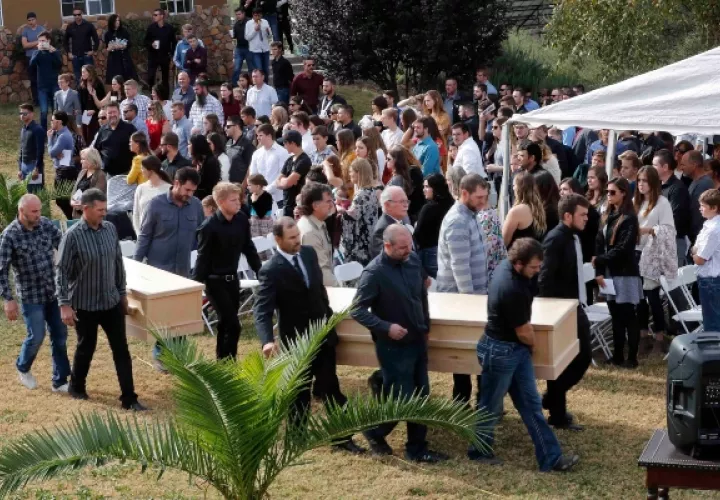 Los hombres llevan los ataúdes de Dawna Ray Langford, de 43 años, y sus hijos Trevor, de 11 años, y Rogan, de 2, que fueron asesinados por pistoleros del cartel de la droga, durante su funeral en el cementerio en La Mora.. FOTO/AP