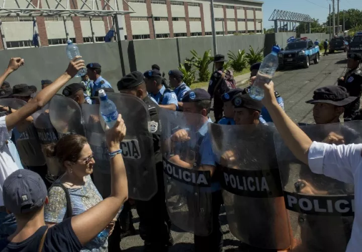 Católicos protestan en las afueras de un templo  contra la policía. EFE