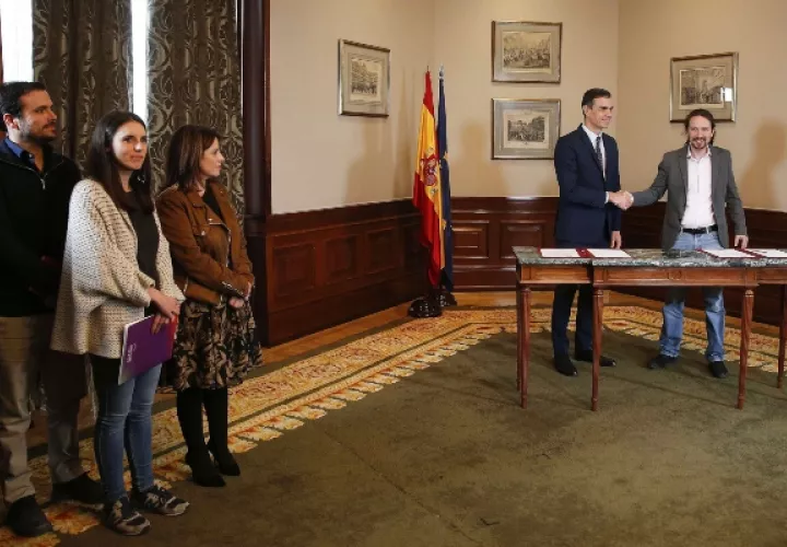 El presidente del Gobierno español en funciones, el socialista Pedro Sánchez (c), y el líder de Unidas Podemos, Pablo Iglesias,d se estrechan las manos tras llegar a un acuerdo para la formación de un Ejecutivo. FOTO/EFE